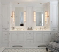 High end bathroom with all white cabinetry and marble countertops, with floor-to-ceiling storage