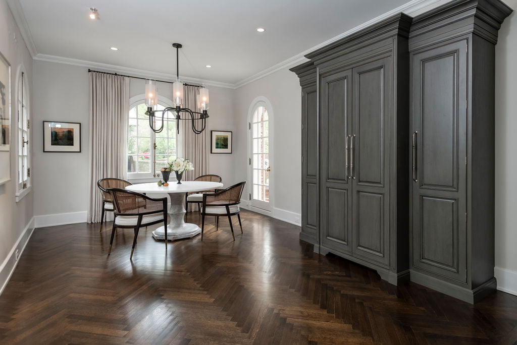 Grey wood transitional armoire on dark chevron hardwood flooring