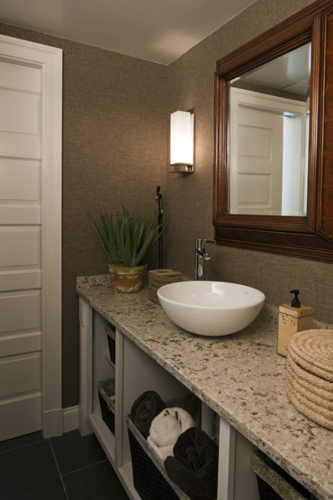 Modern style powder room with granite countertops, raised sink bowl, and large traditional wood-framed mirror