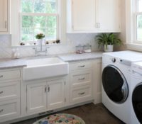 Transitional laundry room with white cabinetry, dark tile flooring, granite countertops, and white decorative tile backsplash