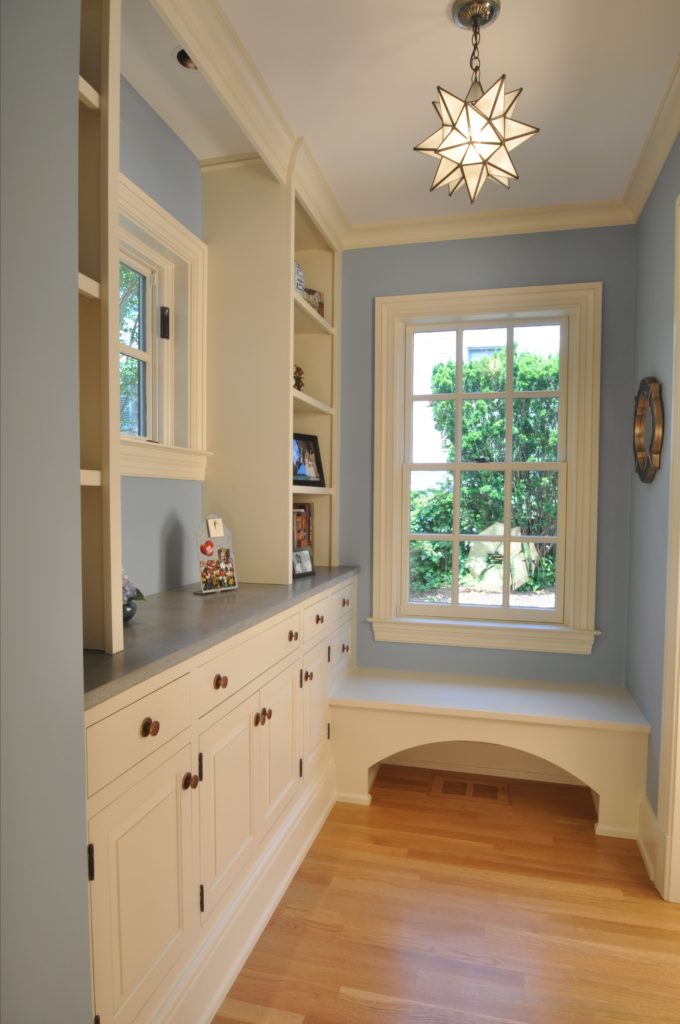 Transitional sitting nook with white drawers and cabinetry and light blue walls, has custom spike chandelier
