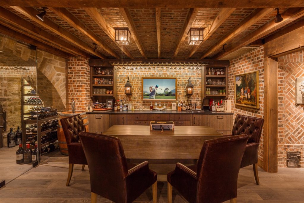 Rustic style brick cellar/basement/bar with fine leather chairs around a wood table