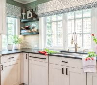 Transitional kitchen sink with custom white cabinetry and dark marble countertops, and a green-hue tile backsplash (Zoomed out)