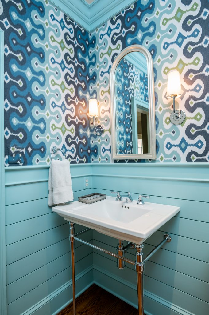 Transitional bathroom with blue wall molding, patterned blue wallpaper, and minimalist white sink