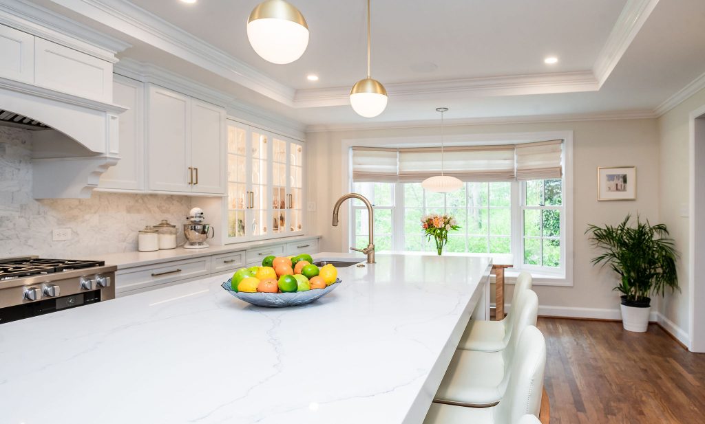 Transitional kitchen island with white marble countertops, orbed flood lights, and high sink faucet