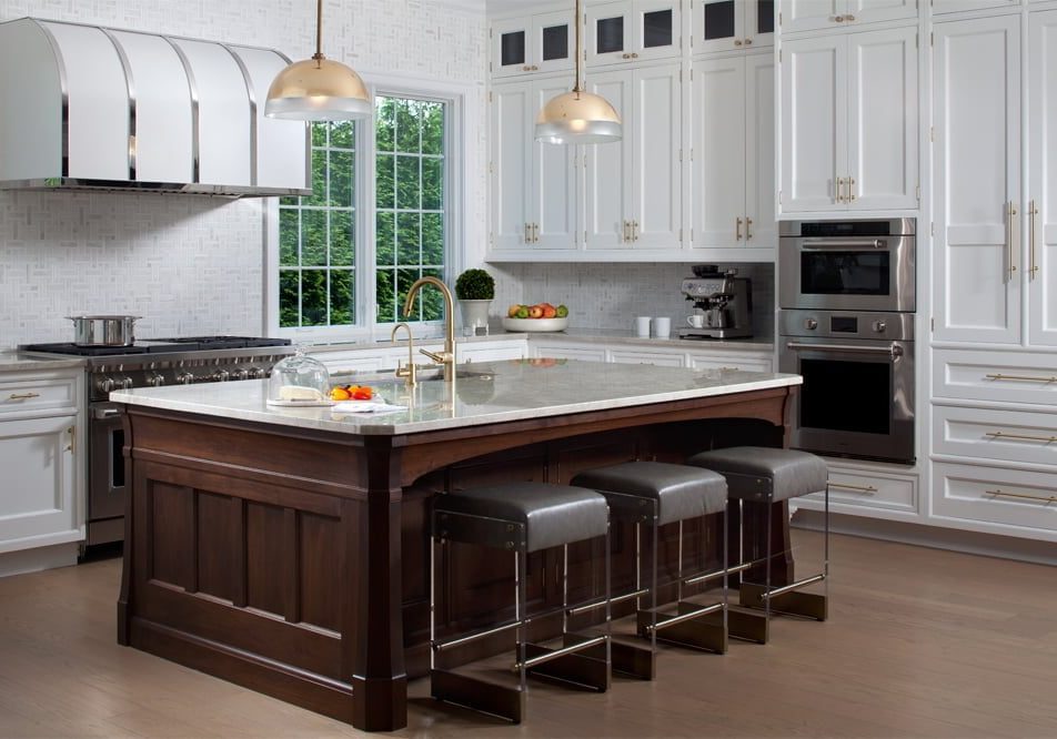 Transitional kitchen island with custom white cabinetry, dark hardwood island , granite countertops and leather stools, and a silver and gold trim