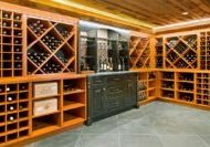 Custom built in-home wine cellar with floor-to-ceiling cabinetry and a wood paneled ceiling